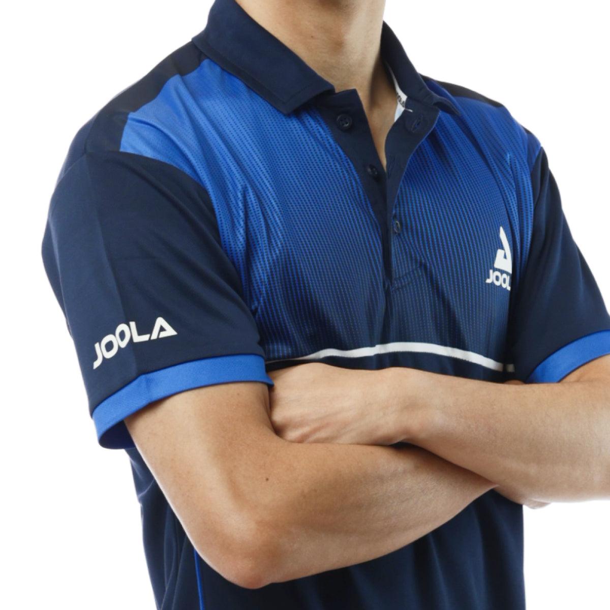 Mann trägt blau-schwarzes JOOLA Sport-Poloshirt mit kurzem Arm und Kragen, Arme vor der Brust verschränkt.