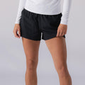 Damen-Sportshorts in Schwarz, an Modell mit weißem Langarmshirt.